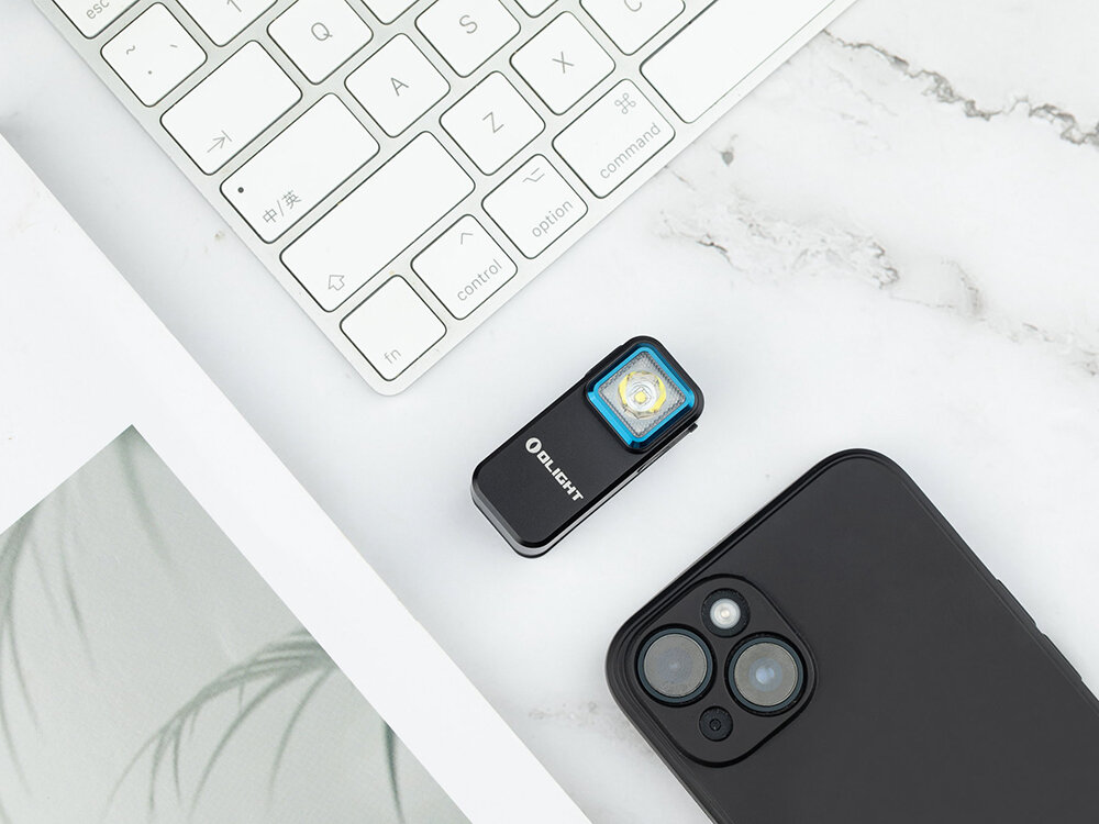 Latarka OLIGHT Oclip OL002703 Czarny, tryby, jasność, stroboskop, SOS, ergonomiczna latarka Oclip obok smartfona