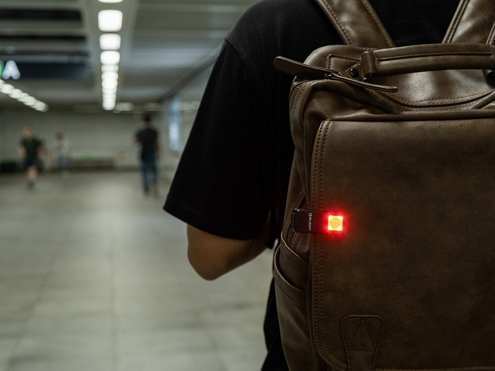 Latarka OLIGHT Oclip OL002703 Czarny, aluminium, anodyzacja, odporność, IPX5, Latarka Oclip świeci czerwonym światłem na plecaku