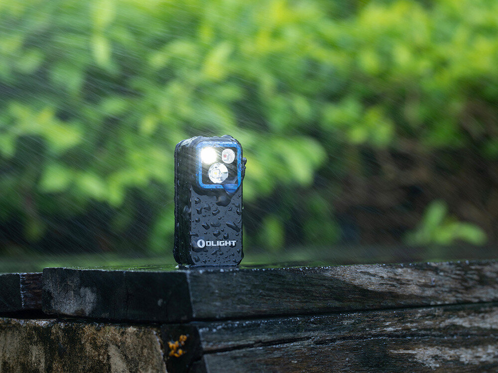 Latarka OLIGHT OL004547, aluminium, odporność, IPX6, outdoor, Oclip Pro na deszczu, strumień wody, zielone tło, odporność IPX6, aktywne diody.