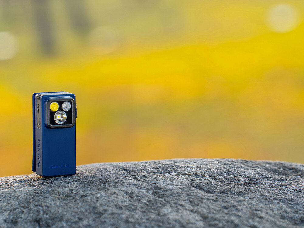 Latarka OLIGHT OL692364, EDC, mocna, wszechstronna, ergonomia, Niebieska Oclip Ultra stojąca na skale w plenerze