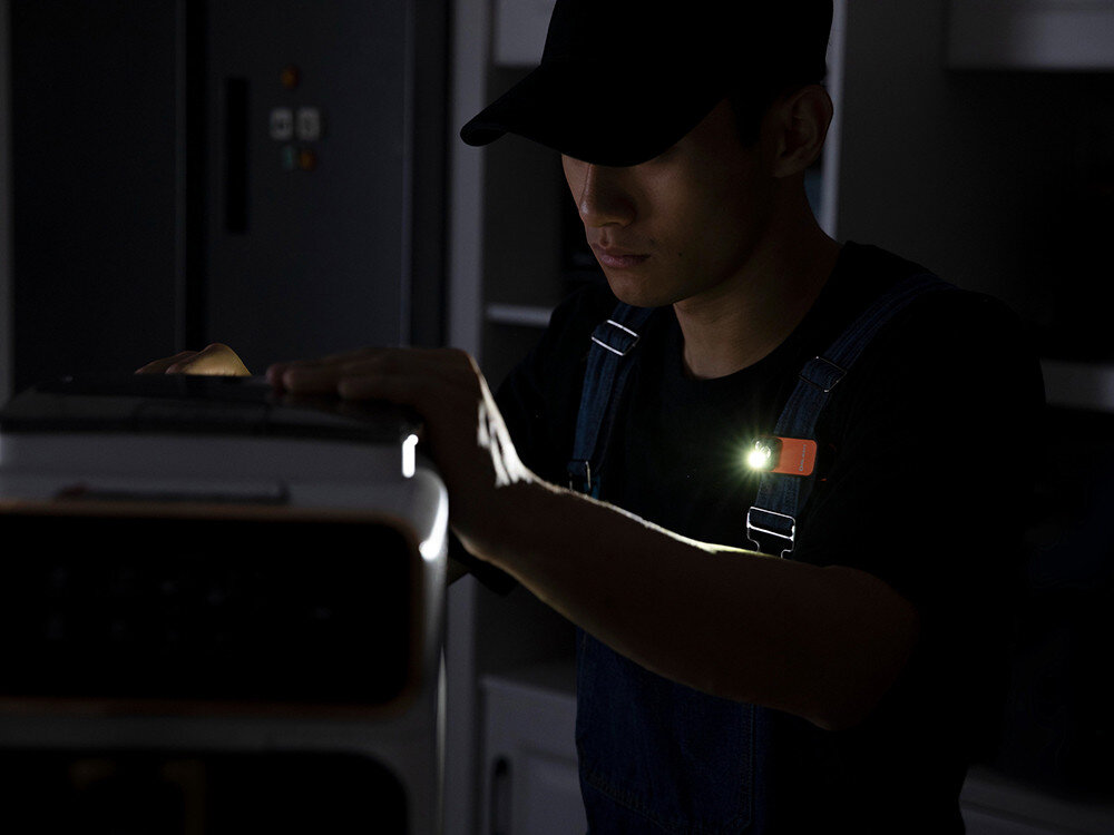 Latarka OLIGHT OL693934, magnes, klips, montaż, linka, Technik w ciemnym pomieszczeniu z Oclip Pro przypiętą do szelek, punktowe oświetlenie pracy.