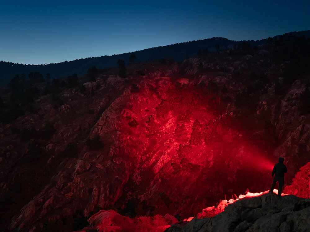 Latarka OLIGHT Marauder Mini QL000549 Niebieski, tryby, kolory, intensywność, taktyczne, Silna czerwona wiązka latarki Olight Marauder Mini, skanowanie skał nocą, postać na grani.