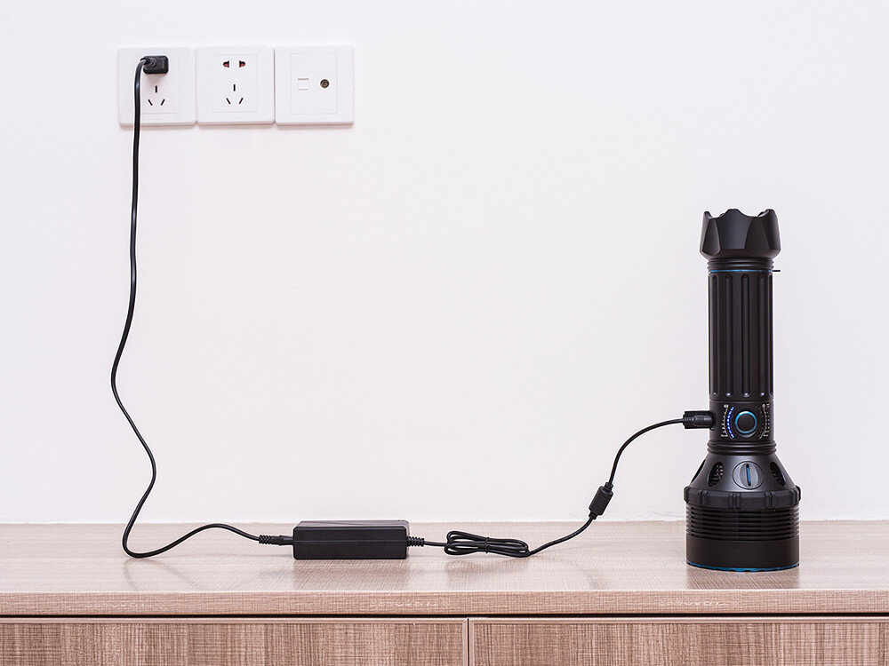 Latarka OLIGHT X9R QL925143, X9R, 25000lm, 630m, eksploracja, X9R podłączona do ładowarki sieciowej