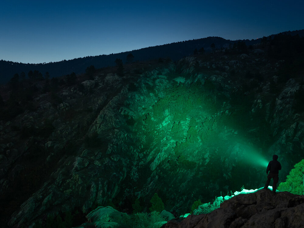 Latarka OLIGHT Marauder Mini QL000983 Zielony, czujnik, bezpieczeństwo, stabilizacja, pamięć, Zielone światło Marauder Mini oświetla skały, nocny krajobraz, postać z latarką.