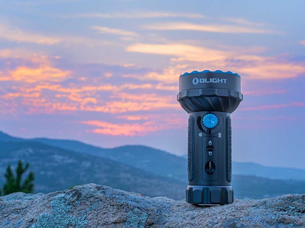 Latarka OLIGHT Marauder Mini QL000495 Czarny, 7000 lumenów, ergonomia, floodlight, RGB, Latarka Olight Marauder Mini na skale, górski krajobraz, zmierzch, wyraźne logo.