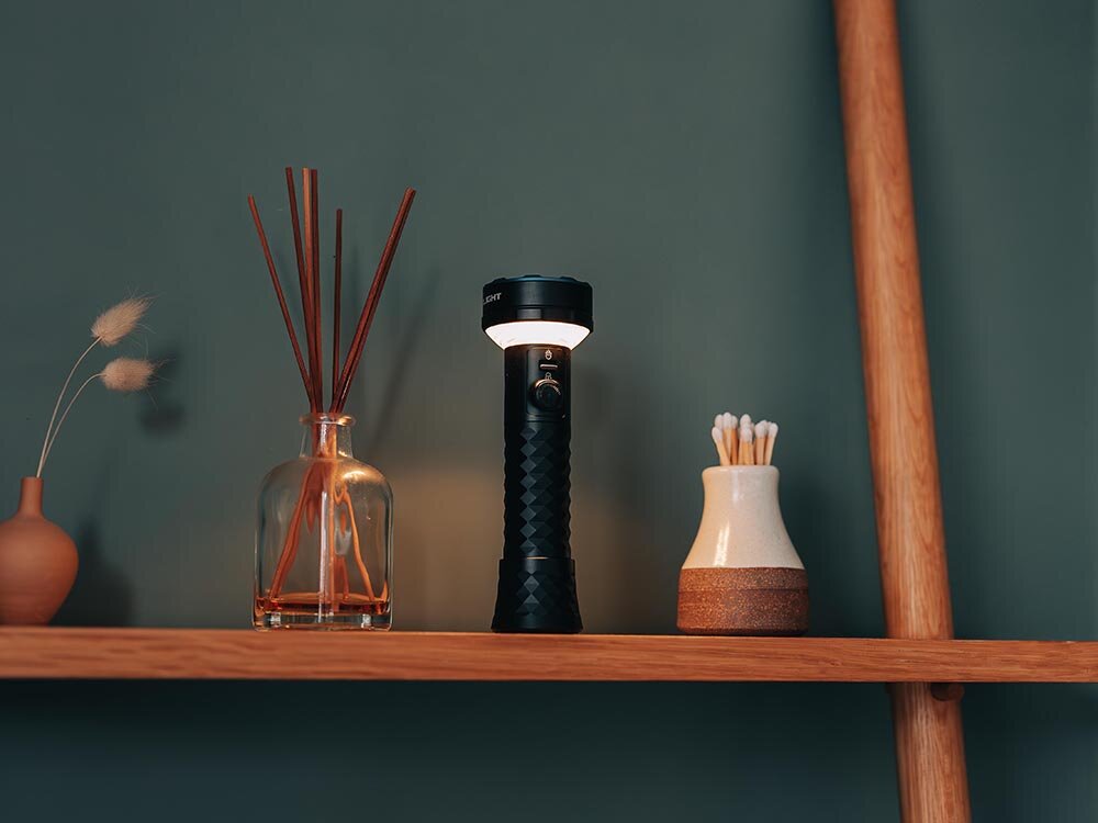 Latarka OLIGHT Prowess QL003670, Dwa źródła, zimne światło, ciepłe światło, zasięg 245m, Latarka Olight jako lampka na półce, stylowe wnętrze z akcesoriami dekoracyjnymi.