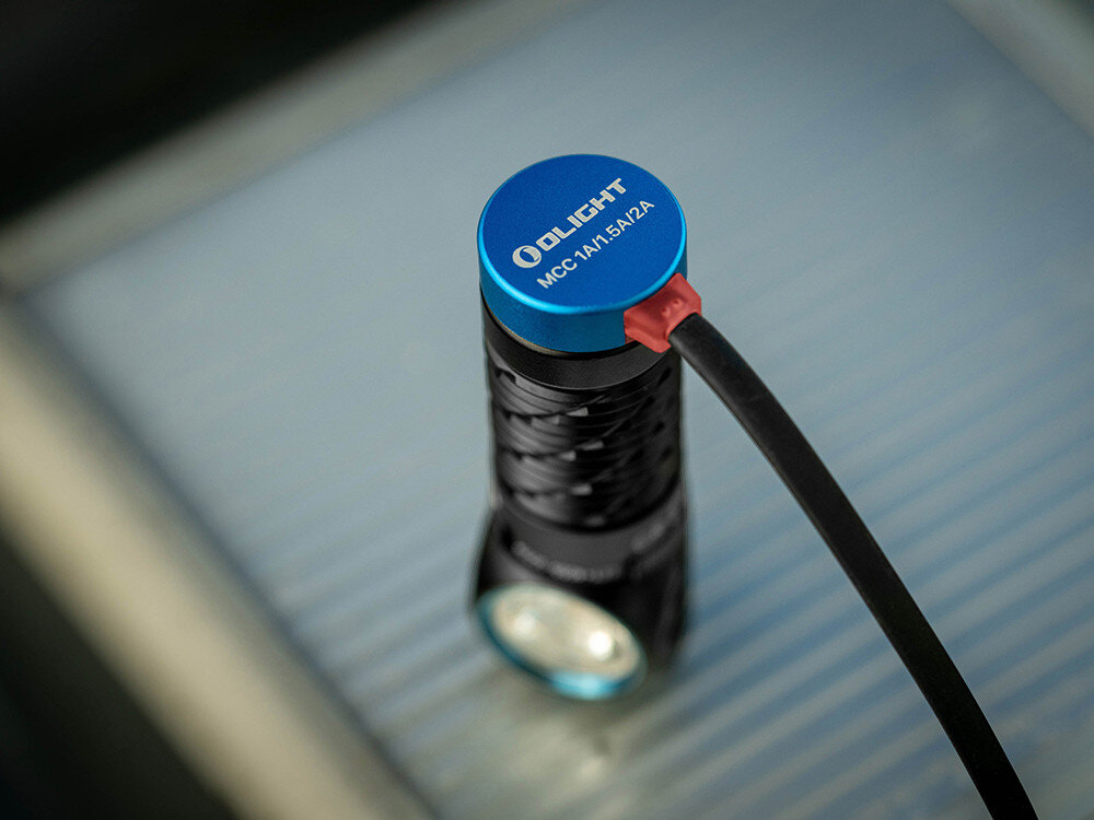 Latarka czołowa OLIGHT QL000594, akumulator, ładowanie, magnetyczne, wskaźnik, Zbliżenie na latarkę Olight ładowaną magnetycznie, niebieska końcówka MCC, detal produktu.