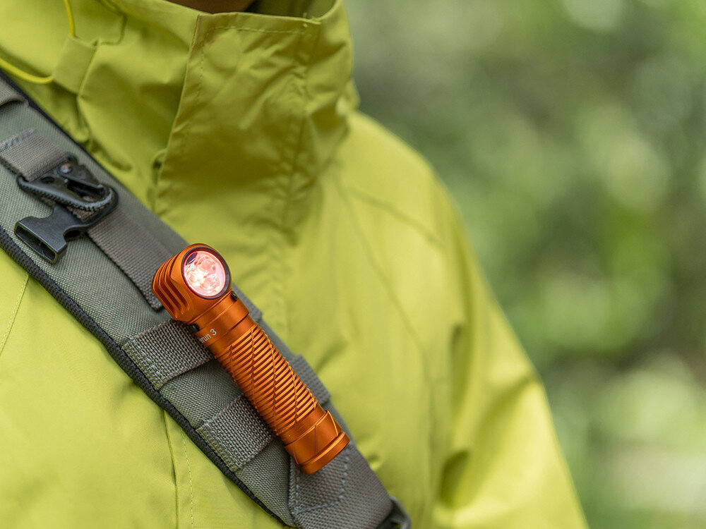 Latarka czołowa OLIGHT Perun 3 QL690216, opaska, klips, magnes, montaż, Latarka Olight zamocowana na pasku naramiennym zielonej kurtki, outdoor, wersja orange.