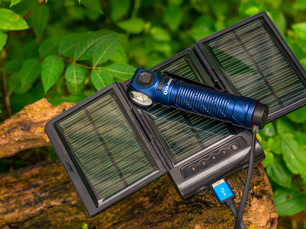 Latarka czołowa OLIGHT Perun 3 QL690490, akumulator, 21700, ładowanie, magnetyczne, Latarka Olight Perun 3 ładowana z paneli solarnych, w lesie na konarze, kabel USB.