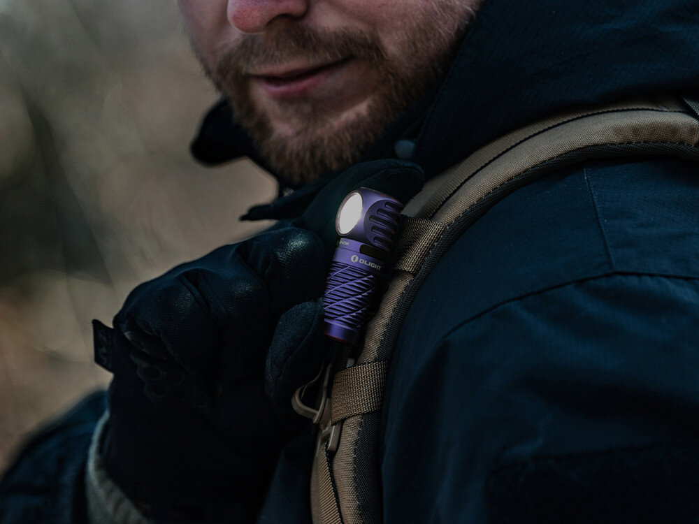 Latarka czołowa OLIGHT Perun 3 Mini QL692838, światło, oświetlenie, ergonomia, uniwersalność, Mężczyzna w rękawiczkach przypina fioletową latarkę Olight do szelki plecaka, outdoor.
