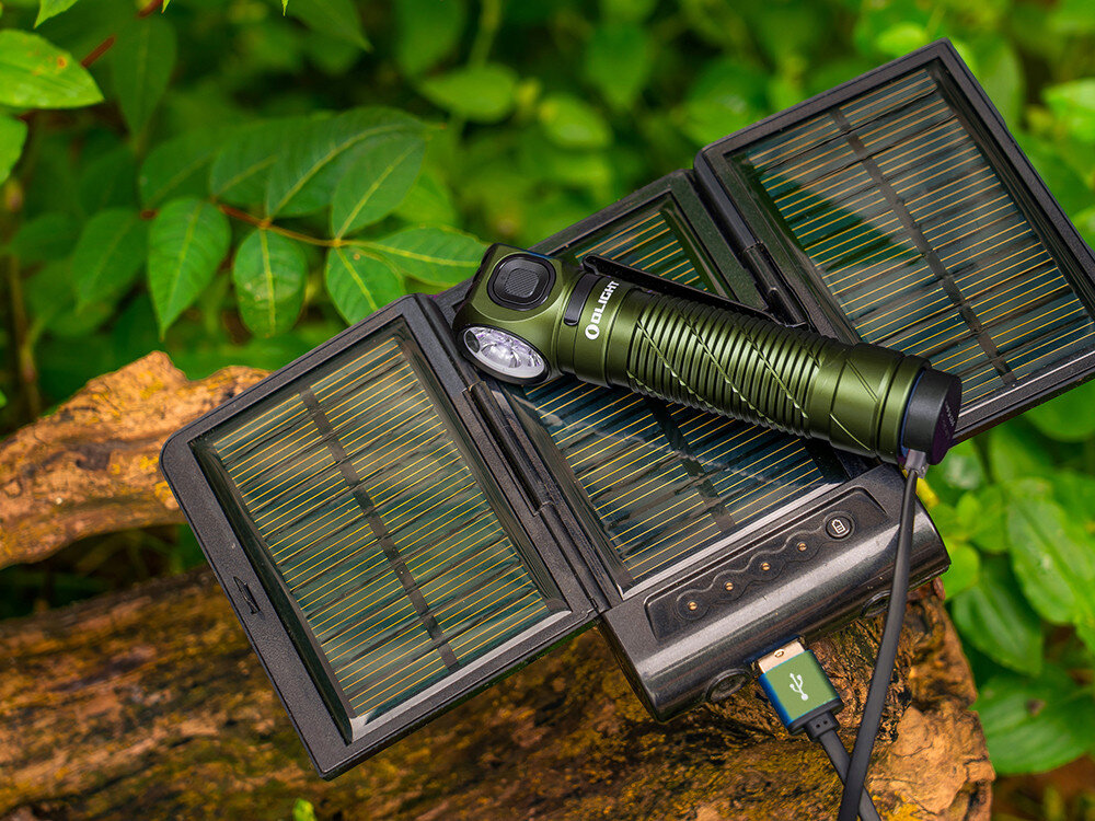 Latarka czołowa OLIGHT Perun 3 QL691534, akumulator, 21700, ładowanie, magnetyczne, Latarka Olight Perun ładowana z panelu słonecznego USB, na tle zielonych liści, plener.