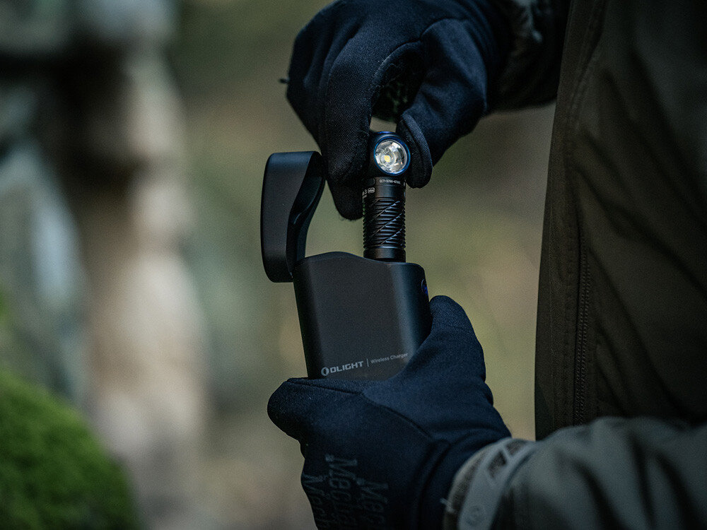 Latarka czołowa OLIGHT Perun 3 Mini Premium QL691282, opaska, regulacja, odblask, komfort, Latarka Olight wyjmowana z etui ładującego przez osobę w rękawiczkach outdoor.