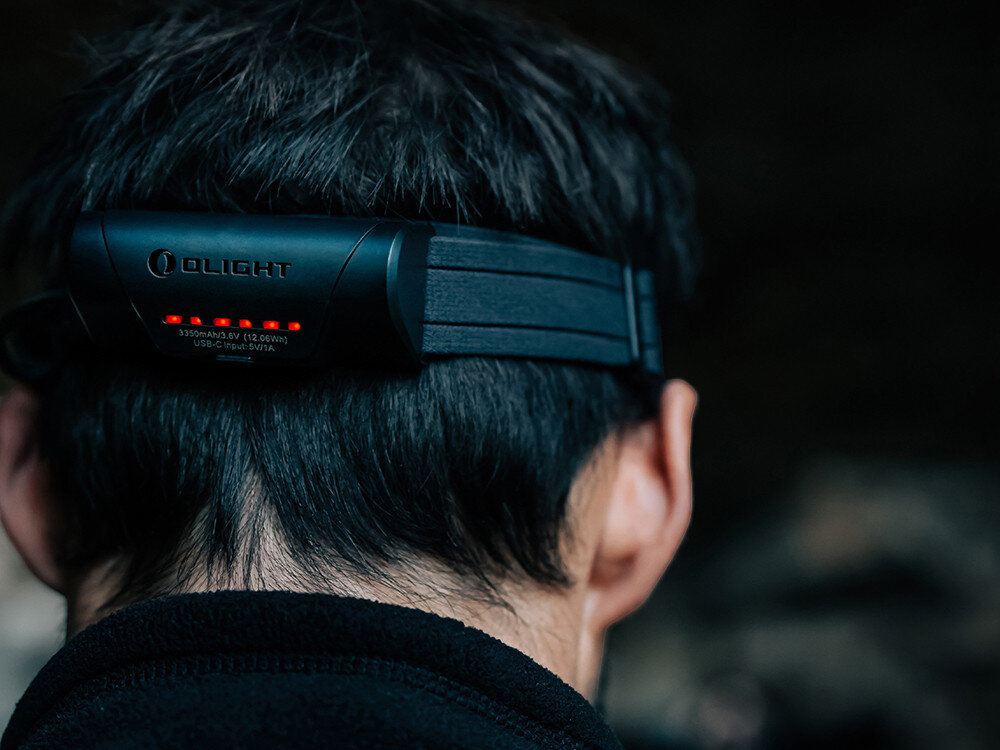 Latarka czołowa OLIGHT Array 2 Pro QL128782, akumulator, USB-C, szybkie, ładowanie, Tył głowy z opaską Olight, widoczne diody LED poziomu baterii, napis producenta, włosy, outdoor.