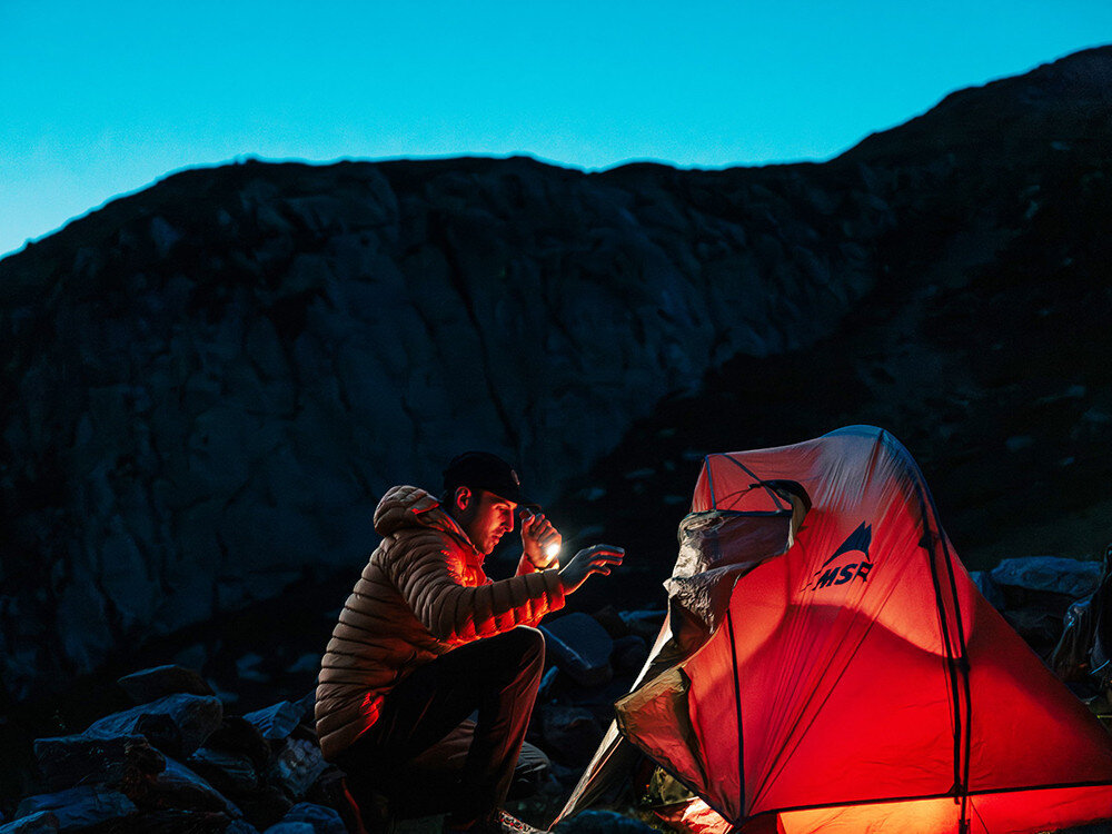 Latarka OLIGHT Seeker 4 Pro QL006169, światło, led, teren, jasność, Trekker sprawdza namiot w górach nocą, latarka Olight, czerwone światło rozświetla płótno.