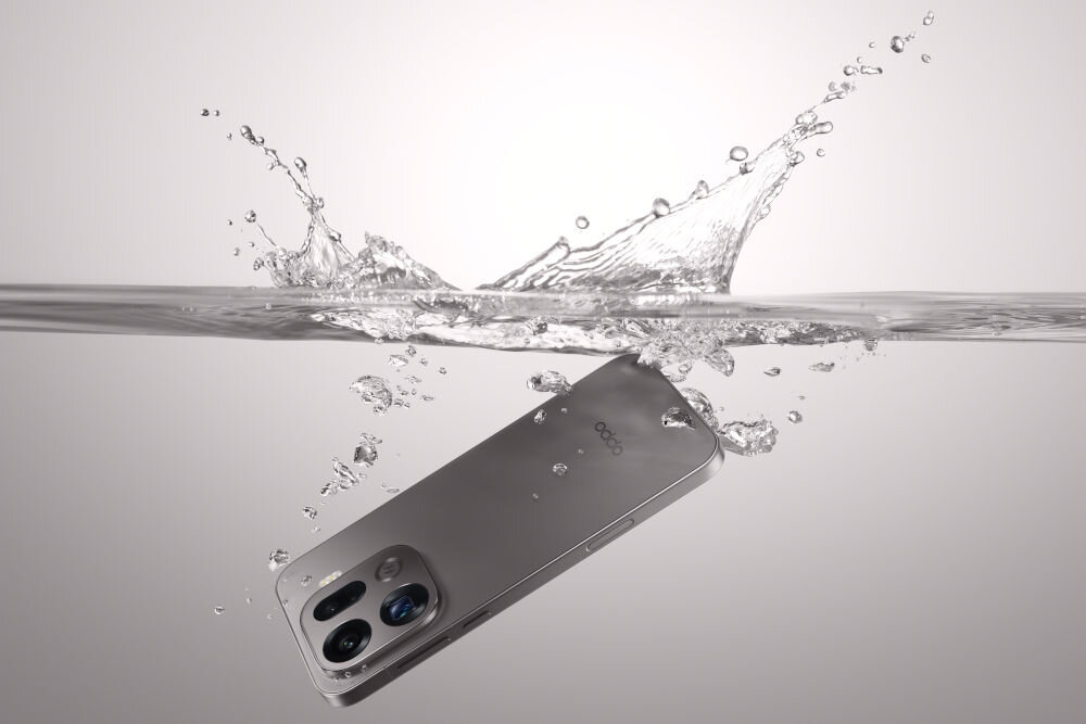 OPPO Find X9 Pro 5G Dual eSIM Wi-Fi 7 Bluetooth 6.0 USB-C IP69 certyfikat wodoodporność Smartfon OPPO w kolorze jasnoszarym/srebrnym zanurzony w wodzie. Woda jest jasnoniebieska, a nad powierzchnią widać duży, dynamiczny plusk. Wokół telefonu unoszą się bąbelki powietrza. Telefon jest skierowany tyłem w górę, z widocznym modułem aparatu.