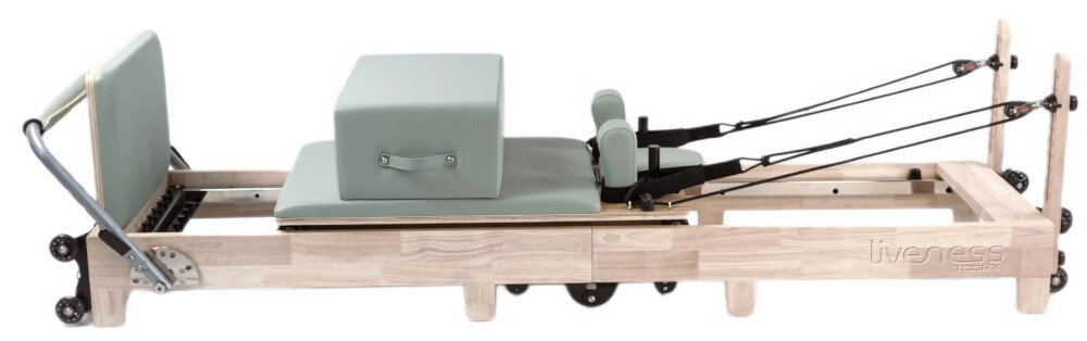 Reformer do pilatesu TOORX Liveness PTX3000 reformer na białym tle widoczny z boku trzypoziomowy zagłówek ergonomiczne oparcie podpórki barkowe wygodna pozycja tapicerka wykonana z mikrofibry pianka o wysokiej gęstości