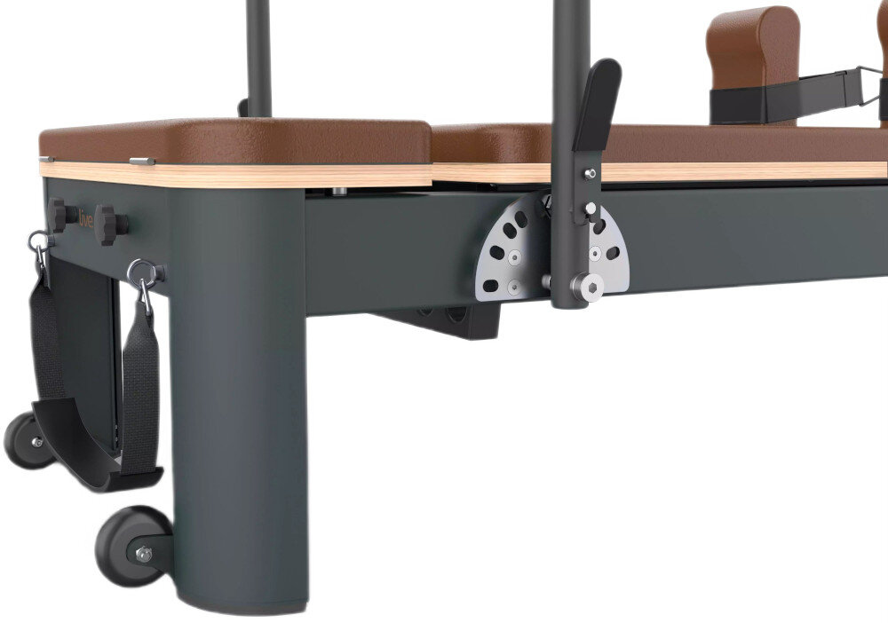 Reformer do pilatesu TOORX Liveness PTX7500 Brązowo-czarny zbliżenie na drążek i mechanizm regulacyjny białe tło sześć sprężyn ze stali hartowanej dwie mocne dwie średnie dwie lekkie można dopasować poziom oporu do doświadczenia użytkownika rodzaju ćwiczeń celu treningowego drążek na stopy oferuje dziewięć poziomów regulacji kąta poza ramą