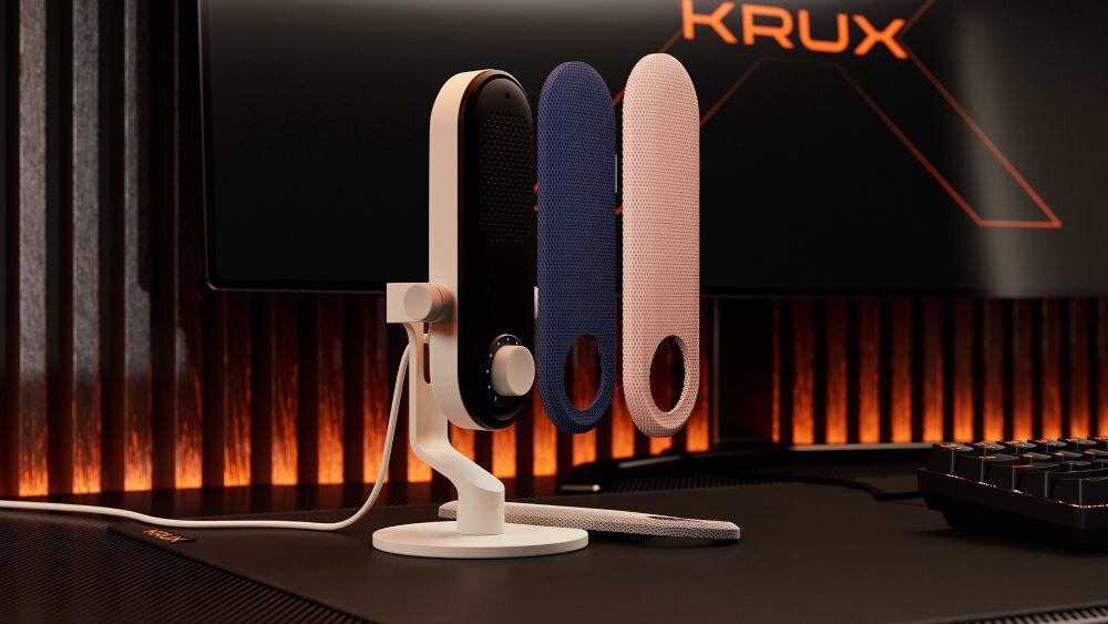 Mikrofon KRUX Pin KRXC019 Kardioidalny Biały Mikrofon KRUX Pin w białym kolorze, stojący na biurku gamingowym, z dwoma wymiennymi panelami (niebieskim i różowym) uniesionymi obok, na tle monitora z logo KRUX możliwość personalizacji wymienne panele dopasowanie mikrofonu do stanowiska pokaż swój styl