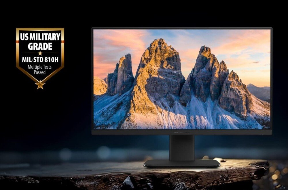 Komputer All in One ASUS ExpertCenter P440VAK-BPCA90X Czarny komputer stacjonarny wyświetlający tapetę ze skalistymi szczytami górskimi o zachodzie słońca, umieszczony na ciemnym tle, z widocznym po lewej stronie złotym znakiem z napisem 'US MILITARY GRADE MIL-STD 810H Multiple Tests Passed', konstrukcja, wielkość, system, wytrzymałość