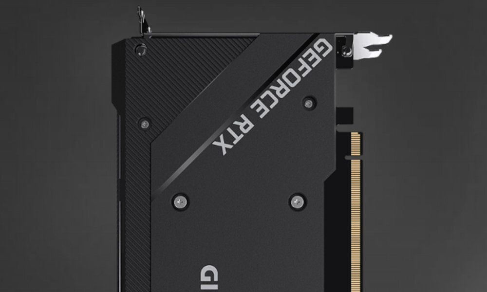 Obraz przedstawia czarną kartę graficzną z widocznym napisem \'GEFORCE RTX\' na obudowie. Widać również fragment złącza PCIe oraz kilka śrub montażowych.
