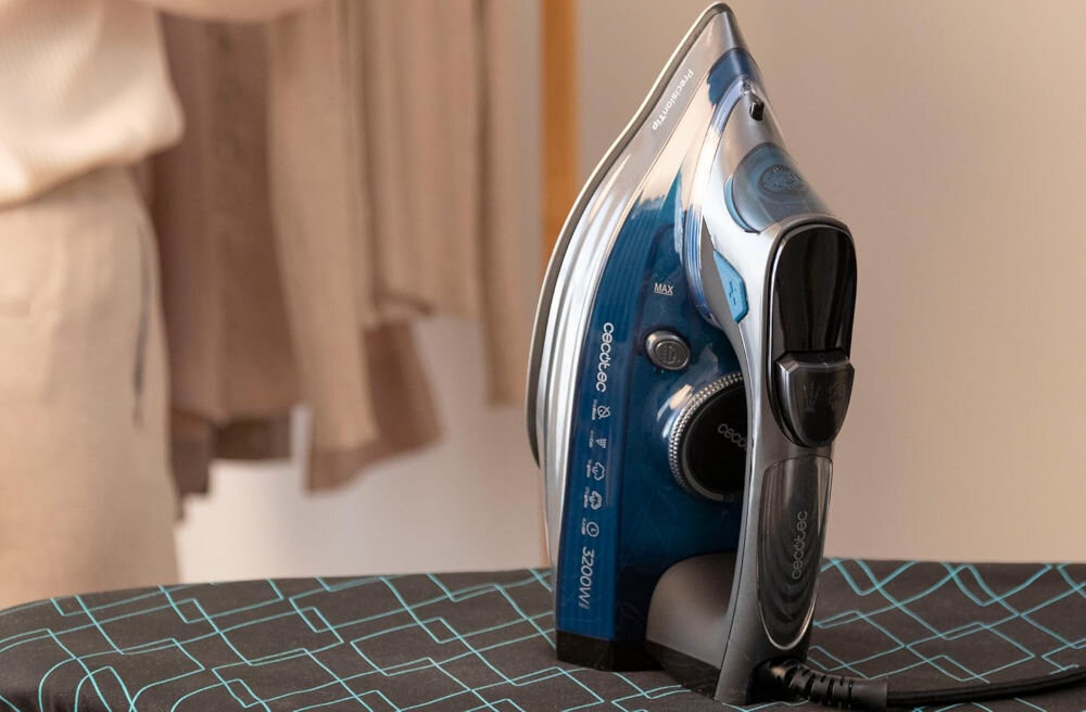 Żelazko CECOTEC IronHero 3200 Smart Absolute żelazko stoi na desce ciemna obudowa przyciski pokrętło intuicyjne pokrętło do różnych materiałów bawełna len tkaniny syntetyczne optymalne rezultaty prasowania Ergonomiczny design praktyczne rozwiązania