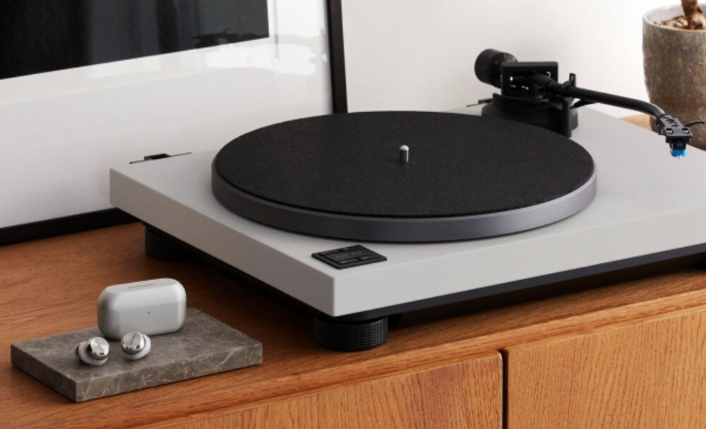 Gramofon TECHNICS SL-40CBTE-H Bluetooth bezprzewodowy odsłuch dźwięk analogowy, gramofon stojący na komodzie obok słuchawek dokanałowych wraz z etui ładującym