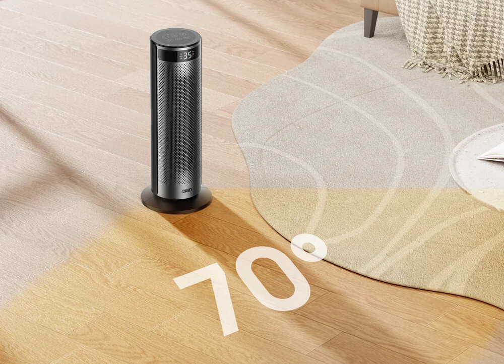 Na drewnianej podłodze stoi cylindryczny grzejnik elektryczny z wyświetlaczem pokazującym \'35\'. Na podłodze widoczny jest napis \'70°\'.