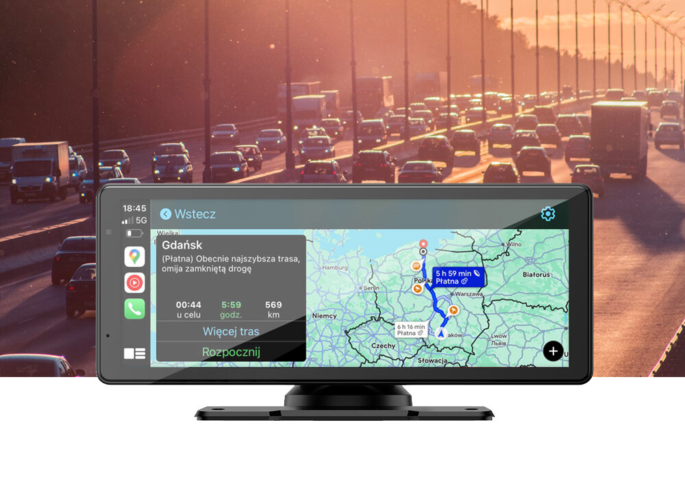Na obrazie widoczny jest samochodowy tablet multimedialny z mapą na ekranie, pokazującą trasę z Gdańska do Warszawy. W tle widać ruchliwą autostradę o zachodzie słońca.