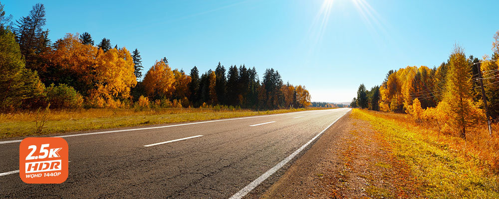 MIO MiVue 903WD rozdzielczości 2.5K (2560 x 1440 px) tablic rejestracyjnych po znaki Technologia HDR (High Dynamic Range) Stabilne działanie kamery - logo 2.5k hdr na tle drogi, w okół lasy