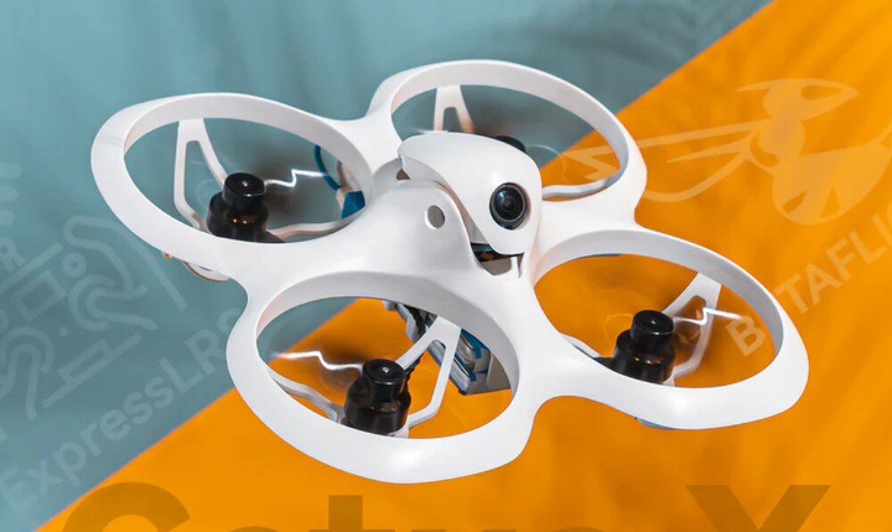 Dron BETAFPV Cetus X FrSky Biały dron z osłonami śmigieł widoczny pod kątem na niebiesko-pomarańczowym tle