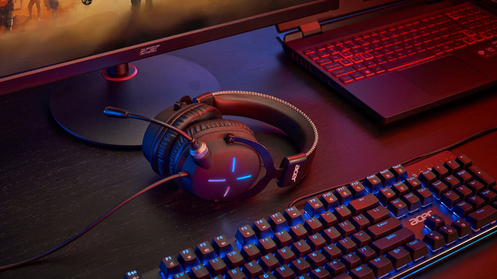 Słuchawki ACER Nitro II NHW200 Nauszne słuchawki leżące na biurku obok klawiatura monitor laptop ciemny blat działa od razu po podłączeniu elastyczne rozwiązanie laptop komputer konsola
