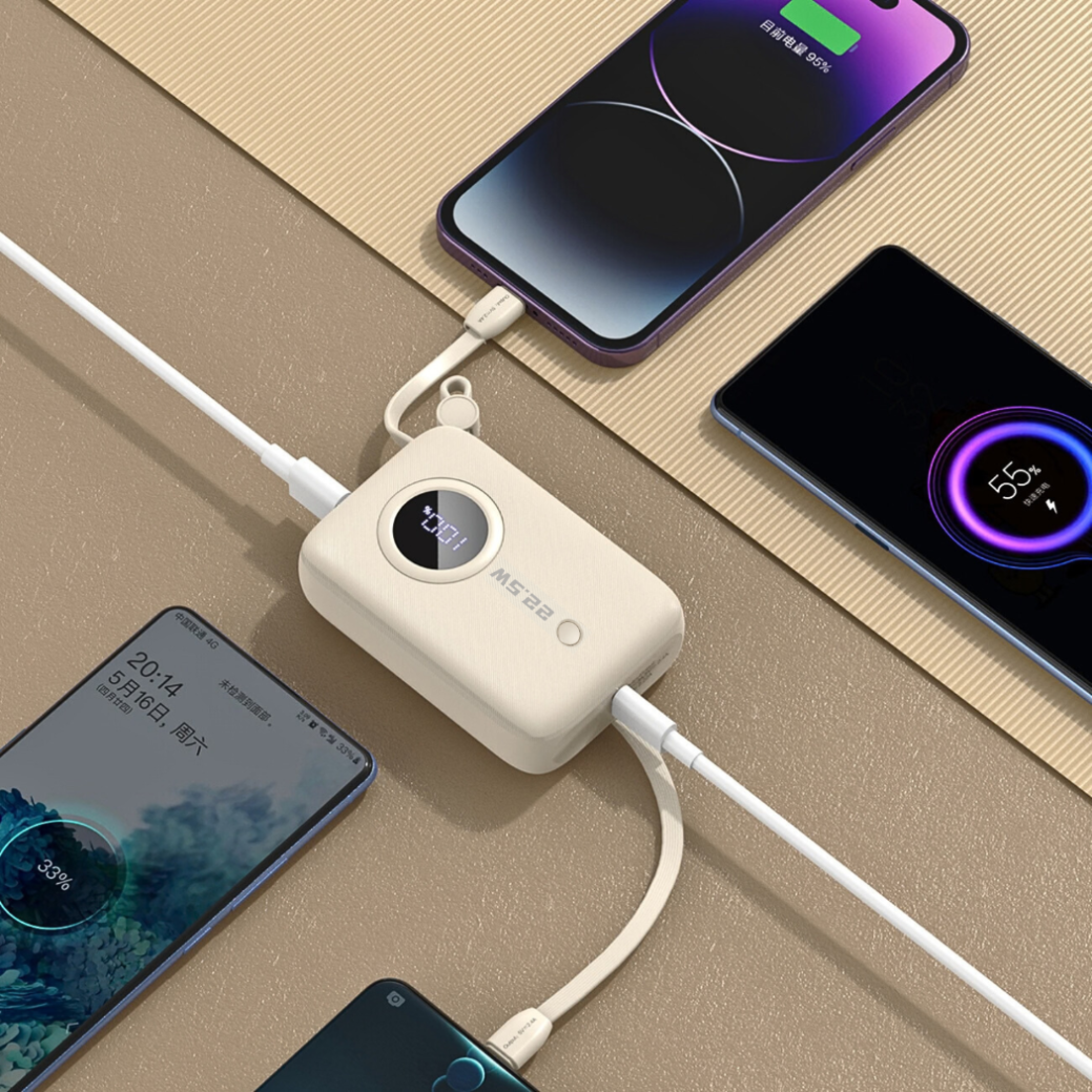 Beżowy powerbank z wyświetlaczem cyfrowym i napisem \'MS 222\' ładuje kilka smartfonów jednocześnie. Urządzenia są podłączone za pomocą kabli USB-C i Lightning.
