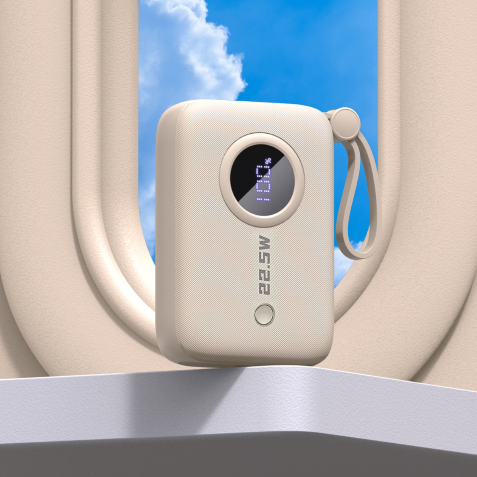 Beżowy powerbank z wyświetlaczem pokazującym 100% oraz napisem \'22.5W\'. Urządzenie ma zaokrąglone krawędzie i pętlę do przenoszenia.