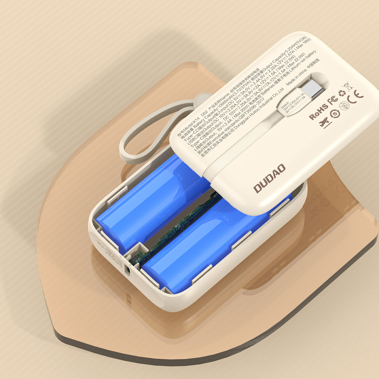 Beżowy powerbank z otwartą obudową, ukazujący dwa niebieskie akumulatory wewnątrz. Na obudowie widoczne są napisy w języku chińskim oraz logo \'DUDAO\'.