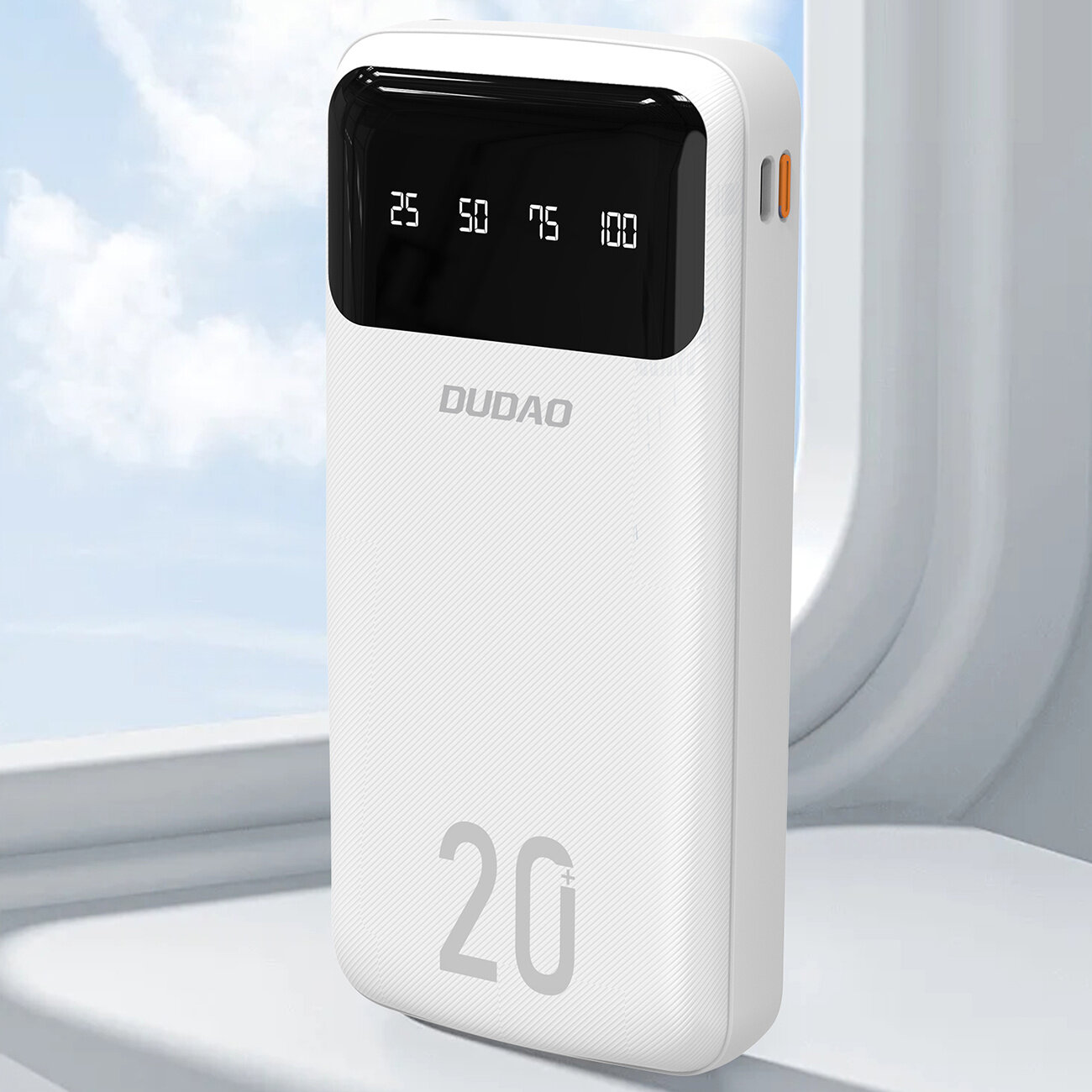 Biały powerbank z wyświetlaczem pokazującym poziomy naładowania: 25, 50, 75, 100. Na obudowie widoczne jest logo \'DUDAO\' oraz liczba \'20\'.