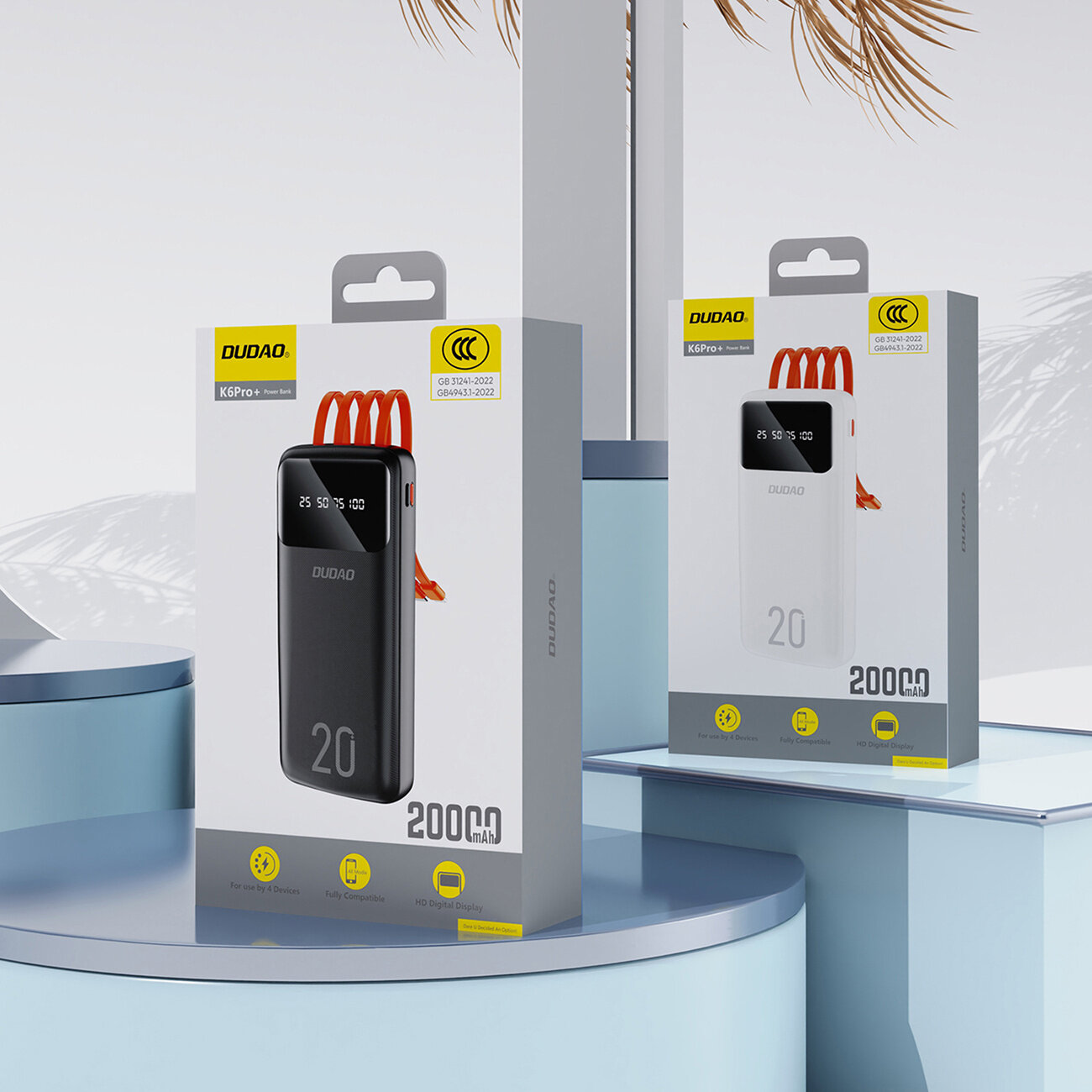 Na obrazie widoczne są dwa opakowania powerbanków marki Dudao, jedno czarne, drugie białe, z oznaczeniem 20000 mAh. Na opakowaniach znajdują się trzy czerwone kable oraz logo Dudao i certyfikaty CCC.