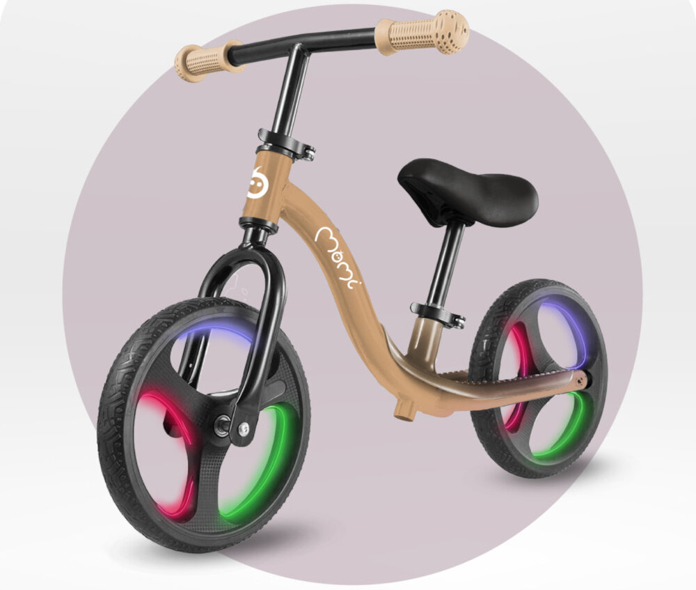 Rowerek biegowy MOMI Isoka Beżowy rowerek na jasnym tle widoczny od przodu pod skosem włączone światła na kółkach aktywność rozwój pierwszy pojazd dziecka