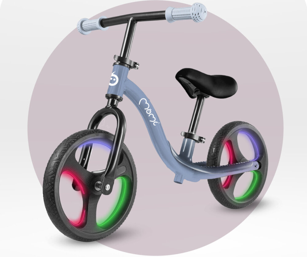 Rowerek biegowy MOMI Isoka Niebieski rowerek na jasnym tle widoczny od przodu pod skosem włączone światła na kółkach aktywność rozwój pierwszy pojazd dziecka