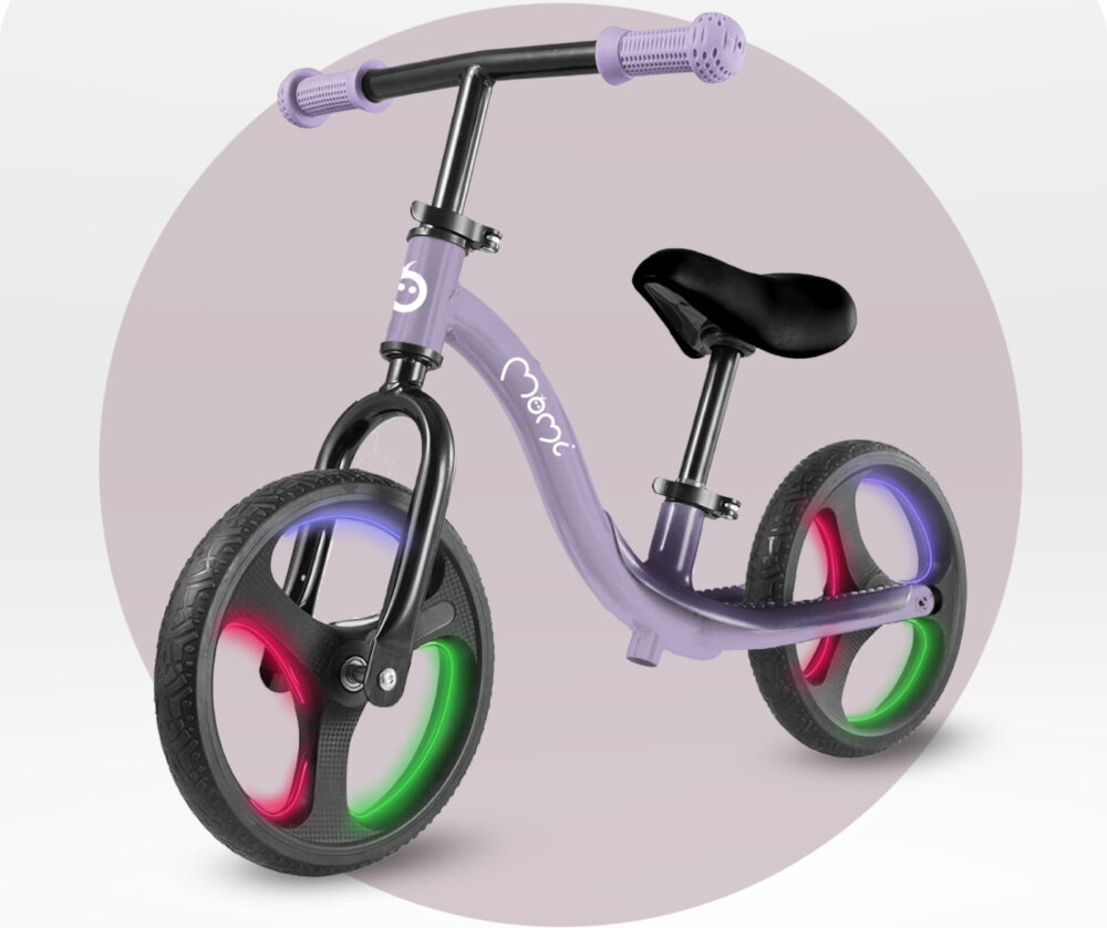 Rowerek biegowy MOMI Isoka Fioletowy rowerek na jasnym tle widoczny od przodu pod skosem włączone światła na kółkach aktywność rozwój pierwszy pojazd dziecka