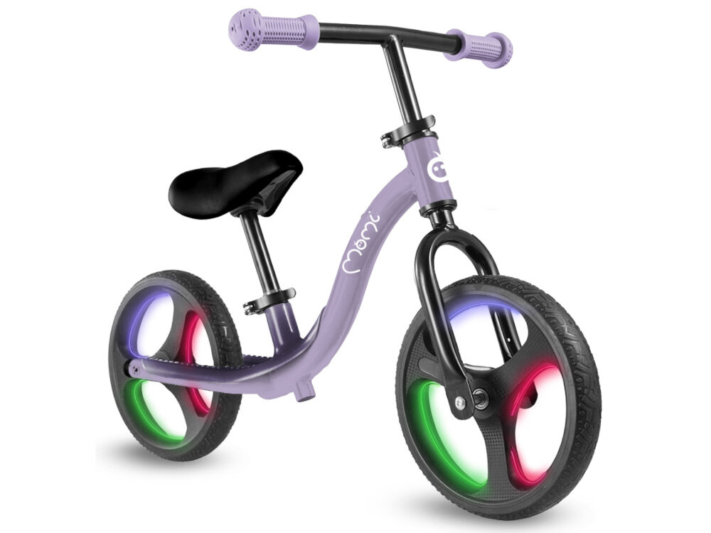 Rowerek biegowy MOMI Isoka Fioletowy rowerek na białym tle widoczny od przodu pod skosem włączone światła na kołach koła ze wbudowanymi światłami LED aktywują się automatycznie podczas jazdy działają na zasadzie mechanizmu dynamo nie wymagają baterii ani ładowania efektowne podświetlenie kół przy każdym ruchu