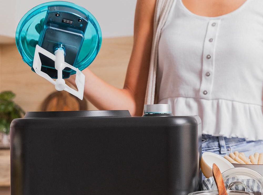 Maszynka do lodów CECOTEC Gelacy 800 maszynka do lodów czarna obudowa osoba wyciąga mieszadło niebieski element system kompresorowy uproszczony proces przygotowywania deseru oszczędność czasu dodanie składników uruchomienie urządzenia błyskawiczne mrożenie komfort użytkowania efektywność