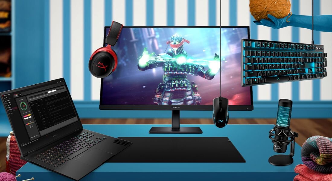 Laptop HP Omen 16 - Monitor komputerowy, mysz, klawiatura i inne przedmioty na biurku, w tym laptop HP Omen 16.  