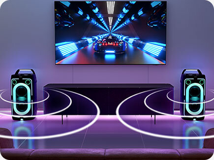 TV in living room displaying gaming scene plays sound via two connected Sound Towers on each side, as shown by soundwaves.
