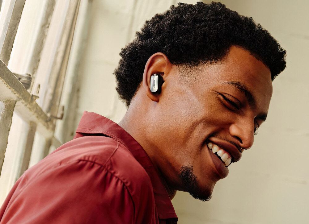 Słuchawki dokanałowe BOSE QuietComfort Ultra spersonalizowane brzmienie redukcja szumów emocje, osoba z założonymi słuchawkami dokanałowymi