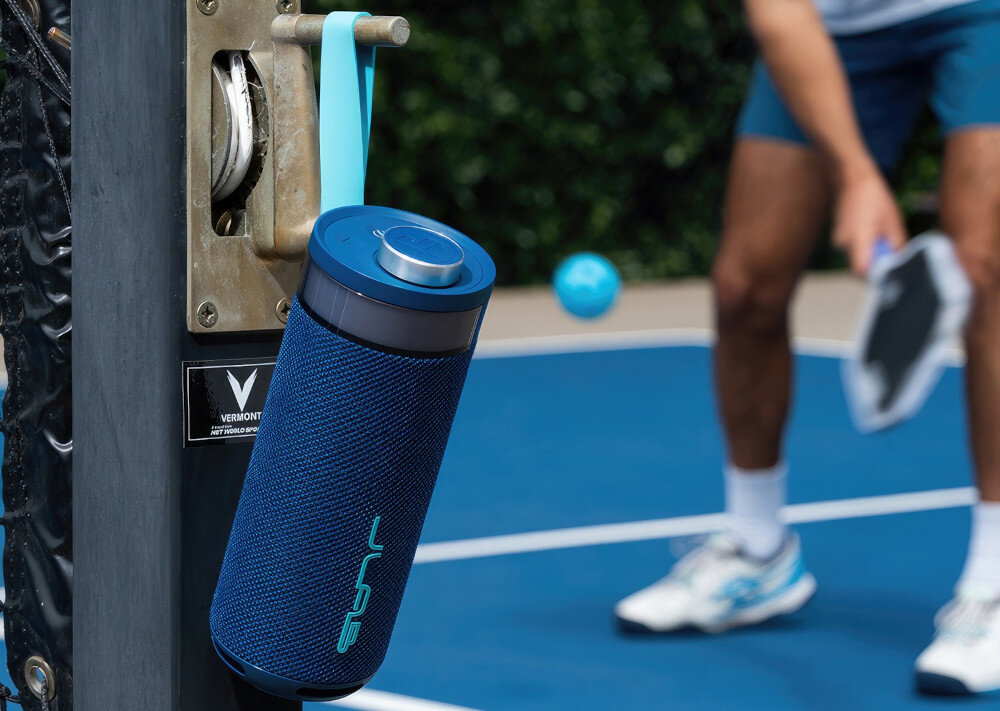 Głośnik JLAB Go Party aplikacja JLab, EQ4, dopasowanie dźwięku, głośnik powieszony na kołku na korcie tenisowym