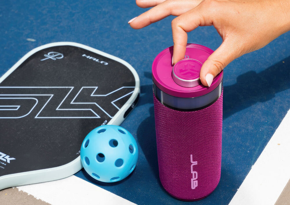 Głośnik JLAB Go Party podświetlenie RGB, sterowanie kolorami i wzorami przez aplikację, ręka trzymająca pokrętło głośnika