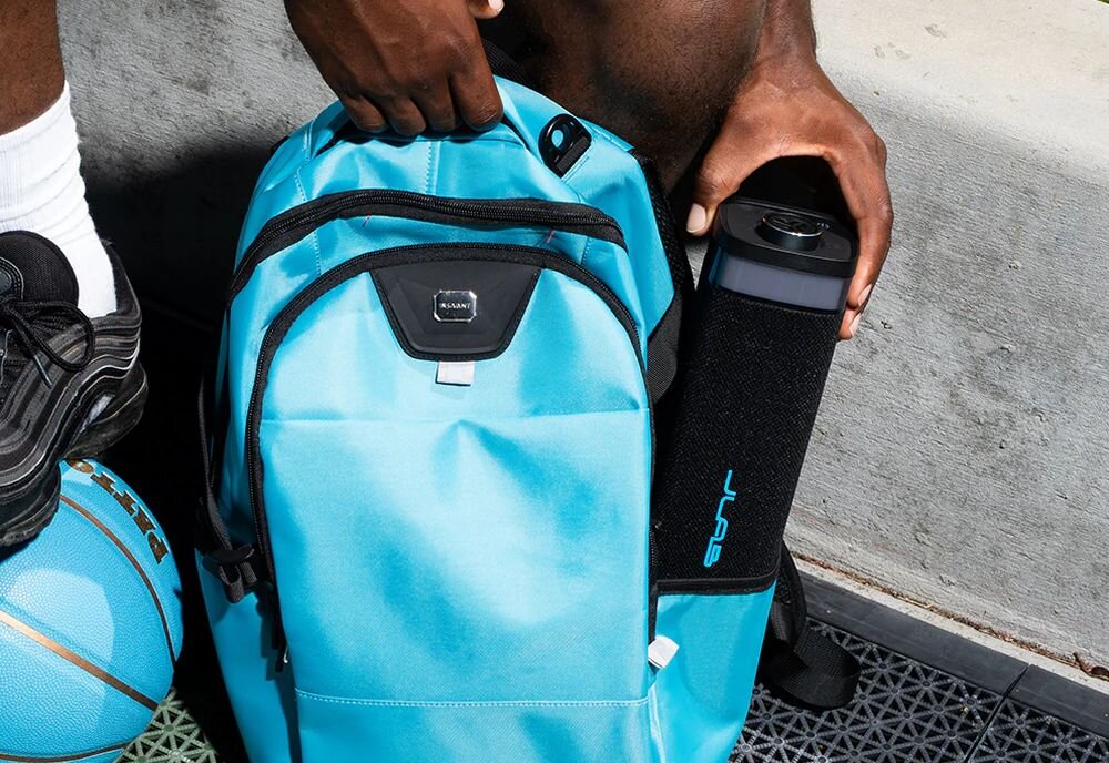 Głośnik mobilny JLAB Jbuds Party podświetlenie RGB efekty świetlne imprezowe, osoba wkładająca głośnik do plecaka