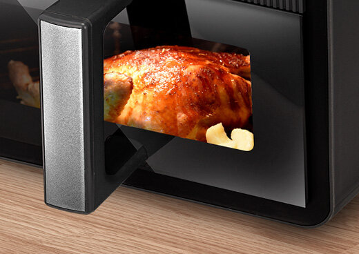 Zbliżenie na podświetlane wnętrze frytkownicy MFR-16, w której znajduje się kurczak.