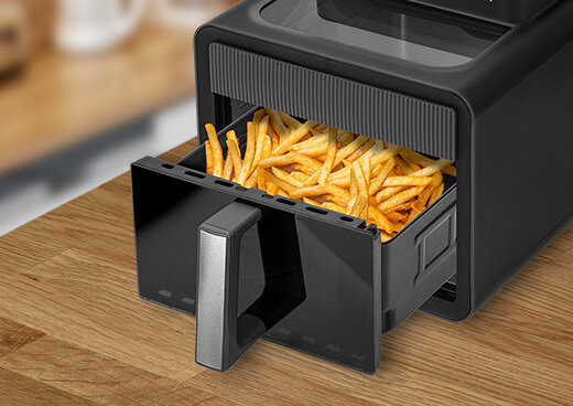 Frytkownica MFR-16 na blacie kuchennym z wysuniętym koszem wypełnionym frytkami.