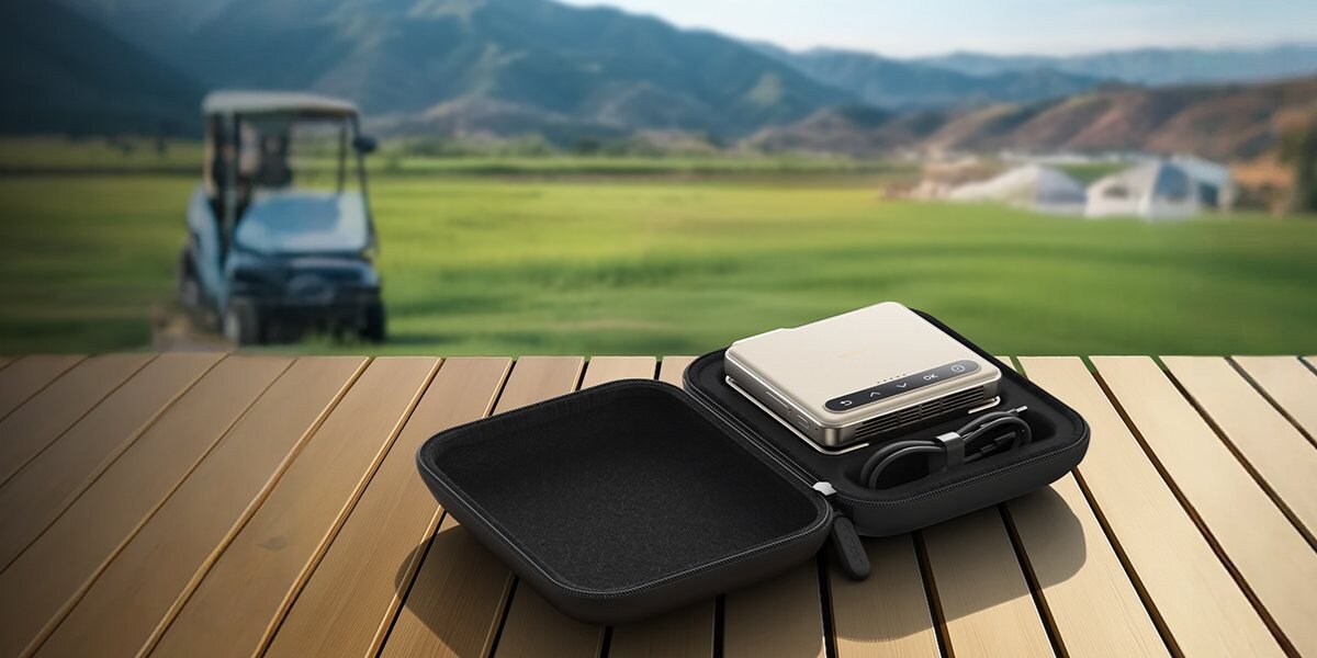 Futerał na projektor AURZEN Caseplay kompaktowa torba transportowa, futerał leżący na drewnianym stole w plenerze